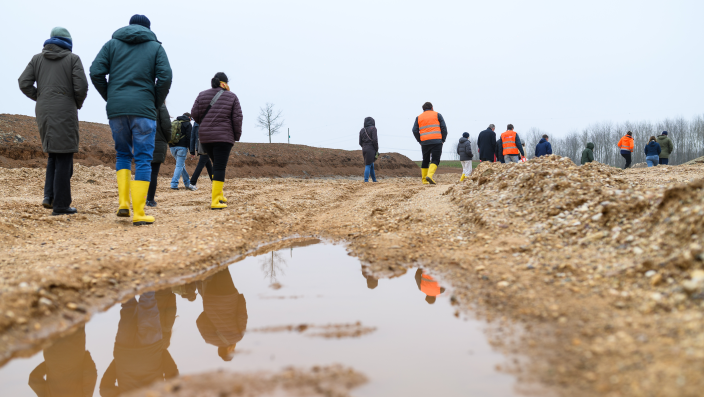 Eine Gruppe geht durch ein trockenes Flussbett mit Pfützen