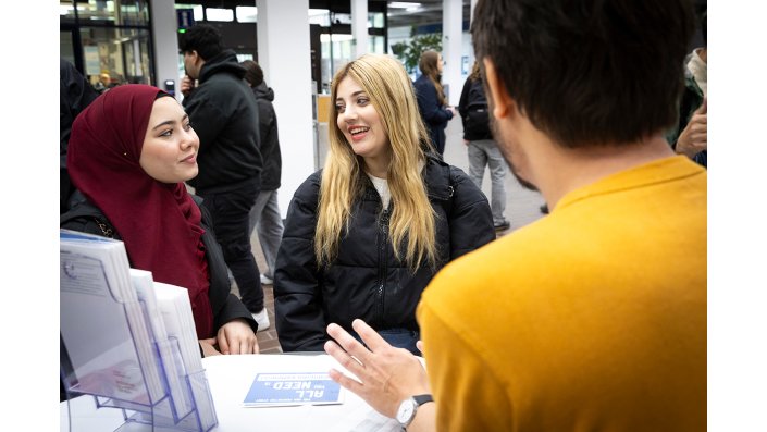 Zwei Studentinnen informieren sich am Infostand im Foyer am Campus Deutz