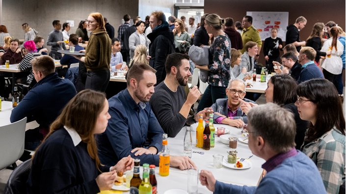 Alumni, Studierende und Mitglieder der Fakultät vertiefen den Austausch bei Fingerfood und Getränken.