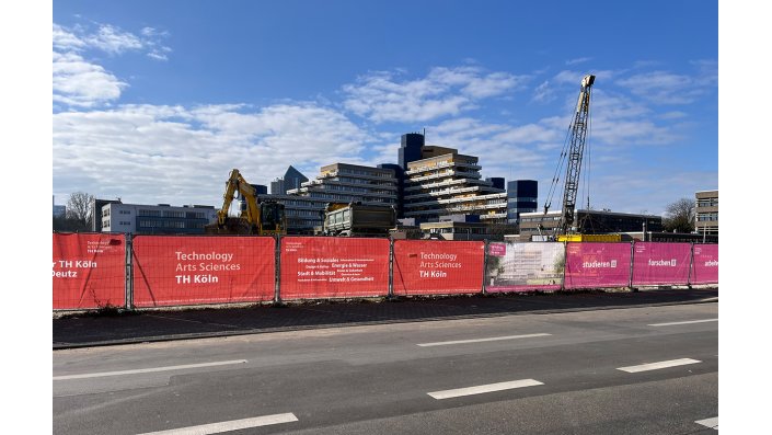 Bunte Bauzaunbanner verschönern die Bauzäune an der Baustelle am Campus Deutz