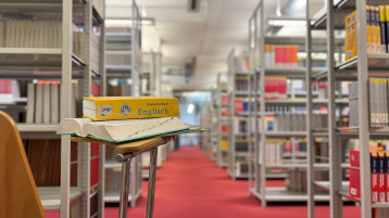 Blick in Lesesaal mit englischem Buch im Fokus (Bild: TH Köln/ Alina Beier)