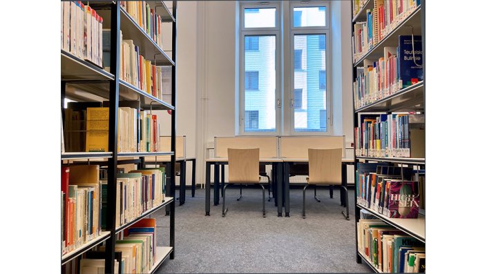 Lichtdurchfluteter Lesesaalbereich mit Bücherregalen und Lernplätzen 