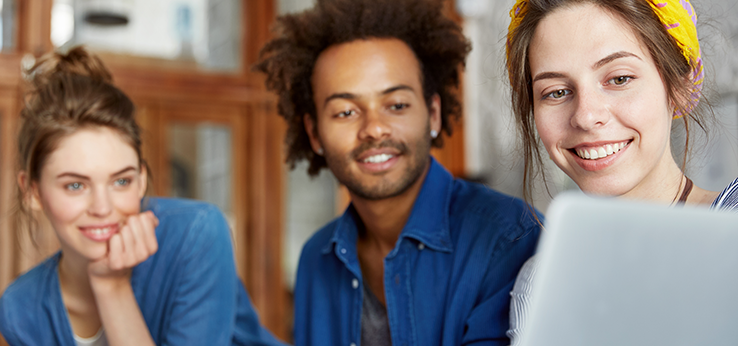 Close-up von 3 jungen Menschen, die gemeinsam auf einen Laptop Screen schauen (Bild: wayhome.studio / Adobe Stock)