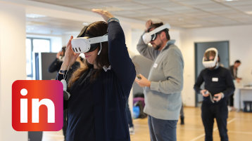 Eine Workshop-Teilnehmererin setzt sich eine VR-Brille auf (Bild: TH Köln)